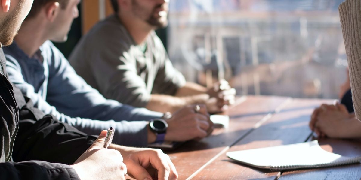 Multiple people having a meeting around a table